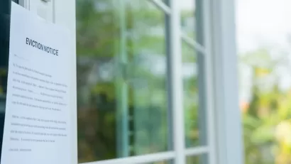 Close-up of eviction notice taped on house door.