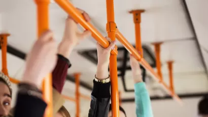Close-up of hands holding straps on public bus.
