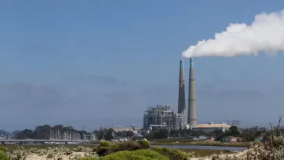 View of natural gas power plant with two tall smokestacks on Northern California coast