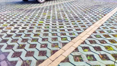 Close-up of green permeable street with concrete lattice over soil and grass.