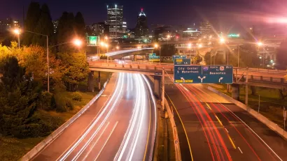 View of blurred traffic lights on Interstate 5 freeway heading into Portland, Oregon at night.