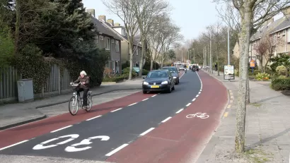Advisory bike lane in The Netherlands with bike rider and cars in center lane
