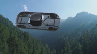 A conceptual rendering of a flying car, pictured in flight over mountains.