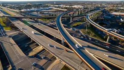 Aerial Texas Hill Country at sunset, with an aerial view of a highway interchange and Interstate 35 in Austin, Texas.