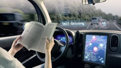 Rendering of autonomous vehicle with woman reading at the wheel