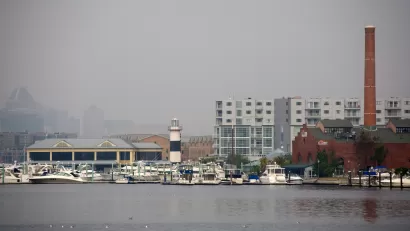 The city of Baltimore's Inner Harbor blanketed in fog, as seen from the water.