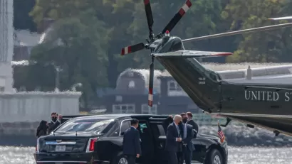 Joe Biden exits a limousine, surrounded by security and staffers, on the way to the Marine One helicopter on a pad near the water in New York City.