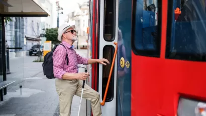 Man with visual impairment boarding public bus