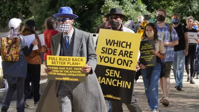 Protesters at the Hart Senate Office Building carry signs calling for Sen. Manchin to support the full Build Back Better Bill.