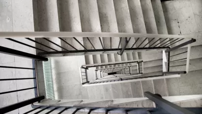 View looking down a multi-story apartment building staircase