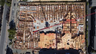 An overhead image of a large wooden building as it's being constructed.