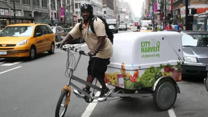 Man riding bike in New York with City Harvest cargo compartment attached