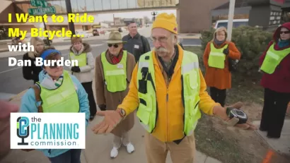 Graphic for The Planning Commission Podcast episode with photo of Dan Burden in safety vest speaking to crowd.