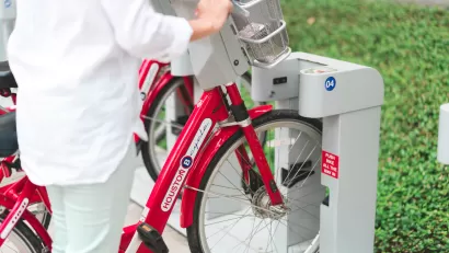 Close-up of person checking out bike at Houston BCycle station with red bikes