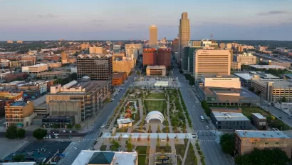 An aerial view of a park and the streets and high-rises of Downtown Omaha.