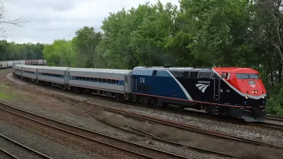 Amtrak Borealis train passing by green forest in Hastings, Minnesota.