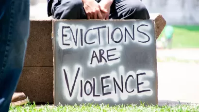 Person holding sign that says "Evictions are violence"