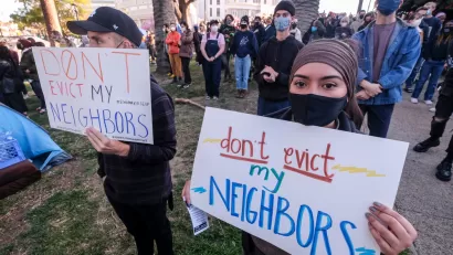 Protestors gather with signs that read “Don’t Evict My Neighbors.”