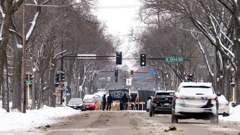Activists creating a DIY blockade in a snowy Minneapolis intersection during 2025-2026 ICE occupation.