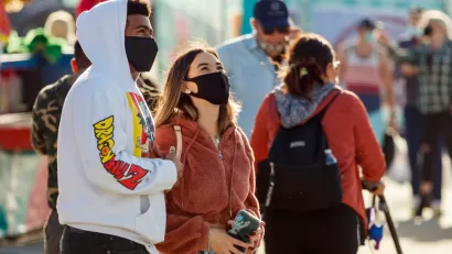 Two young people wear masks while standing outside in Florida.