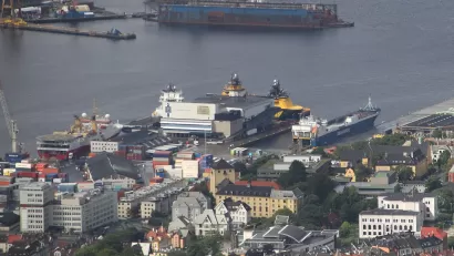 Dokken is a western part of the Port of Bergen (Norway). At Dokken is the large, white Port Warehouse, in which a small brown/black building (in the center of this image) is the WWII German anti-aircraft artillery bunker (RK-ID 212746).