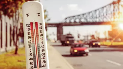 Thermometer infront of blurred image of street during heat wave