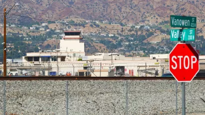 A picture of two street signs with the Hollywood Burbank and hills int he background.