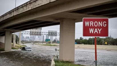 Flooded freeway underpass with red and white WRONG WAY sign in Houston, Texas during Hurricane Beryl in July 2024.