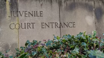 Weathered stone slabs with the words Juvenile Court Entrance engraved into it.