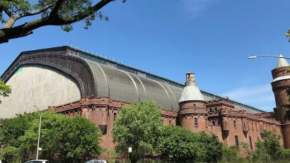 Kingsbridge Armory, large hangar-like brick building in the Bronx, New York City with brick lower floors and glass/metal curved roof..