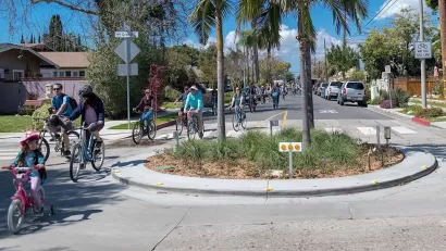 Group of people and kids biking through small roundabout in Long Beach, California.