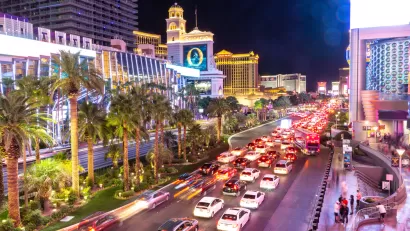 The Las Vegas Strip, pictured at night with lights and illuminated and Las Vegas Boulevard congested with cars.