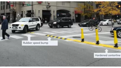Crosswalk in Chicago with newly installed yellow delineators and speed bumps