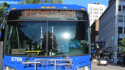 Close-up of front of blue MCTS bus with "Ride MCTS" on marquee in urban Milwaukee neighborhood