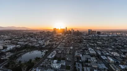 An aerial view of Los Angeles at dawn, with Westlake and MacArthur Park in the foreground and Downtown Los Angeles in the background.