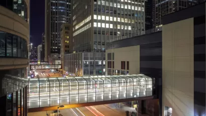 A series of pedestrian bridges, linking buildings on either side of the street, are illuminated int he night in downtown Minneapolis.