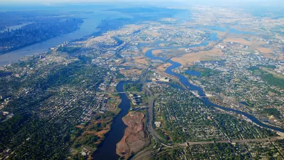 An aerial view of New Jersey suburbs, with Manhattan and New York City in the distant background.