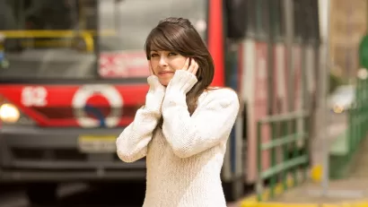 portrait of woman walking on the city street covering her ears