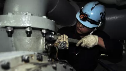 Japanese shipyard worker performs preservation work on ships air conditioning system.