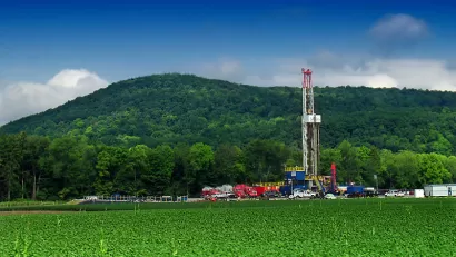 Marcellus shale gas-drilling site with tall white tower against green hills along PA Route 87, Lycoming County, Pennsylvania