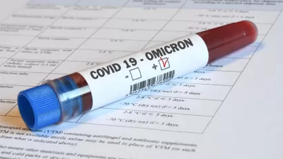 A vial of blood marked "Omicron" sits on top of paperwork indicating relevance to Covid-19.