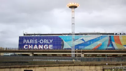 The exterior of a terminal at Orly Airport in France, with a large graphic that reads “Orly Change.”