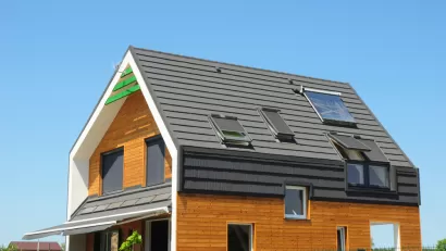 Modern Passive House Exterior. Modern energy efficiency house with skylight windows and solar panels on the roof top.