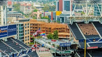 An image of stadium seats at Petco Park in San Diego, with new buildings under construction nearby in the background.