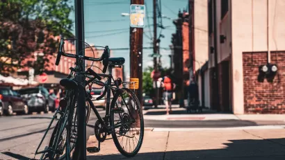 A pair of bikes are leaning against a street sign on an urban street in Philadelphia.
