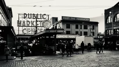 Black and white photo of Pike Place Market entrance in Seattle with "PUBLIC MARKET" and "Meet the producer" signs