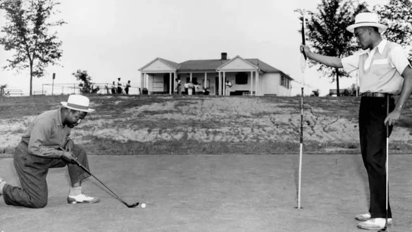 Black and white photo of two Black men playing golf at Langston golf course in Washington, D.C.