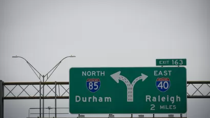 A freeway sign for an intersection showing Interstate 85 for Durham on the left and Interstate 40 for Raleigh on the right.