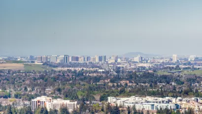 A view out over the city of San Jose, with downtown highrises in the background distance and smoggy air hanging overhead.