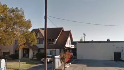 Google street view of late Victorian home in Harvard Heights neighborhood of Los Angeles, with one-story commercial building next door.